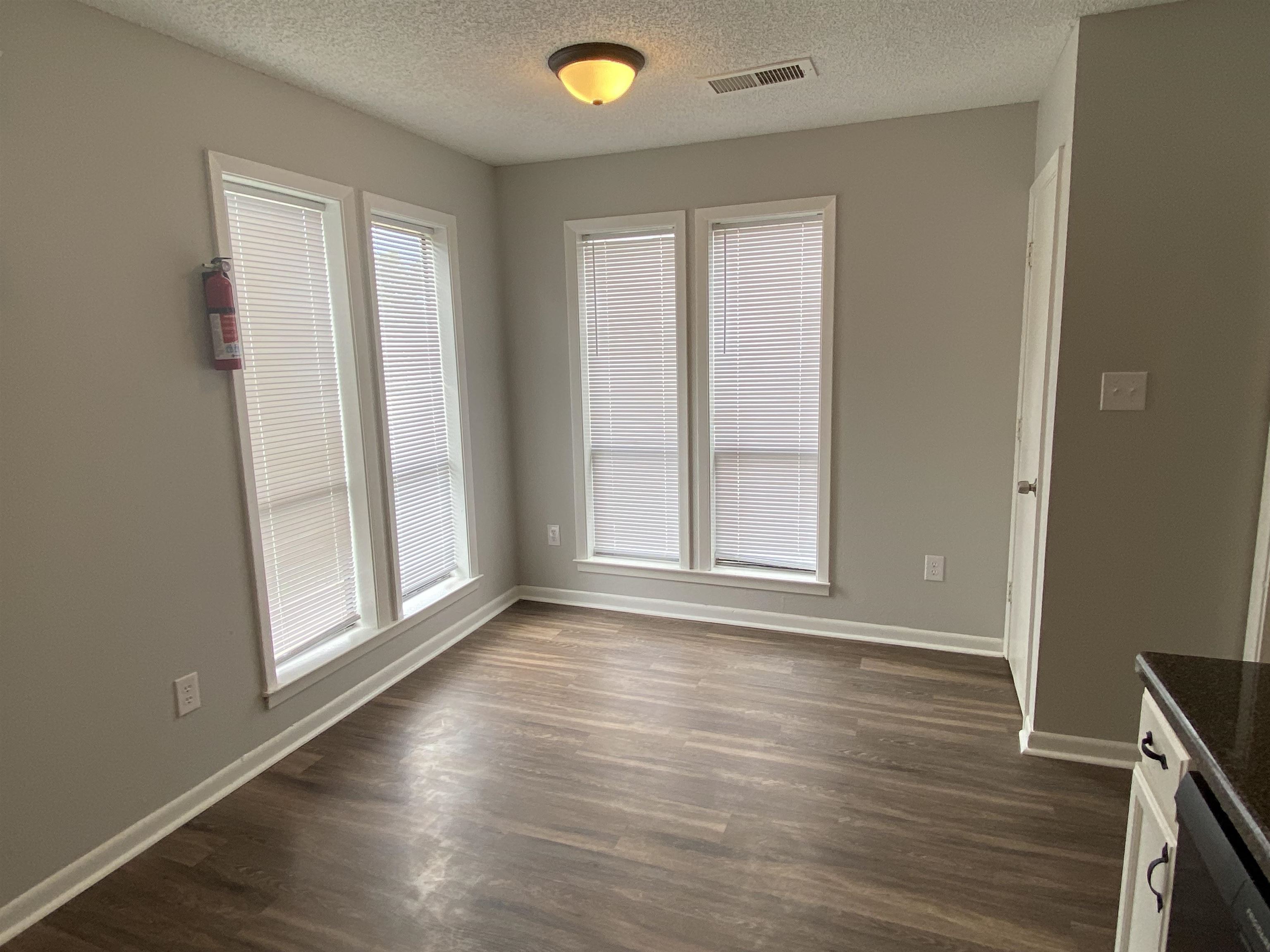 3891 Ross Road Memphis, TN 38115 - Photo 9 of 18 an empty room with wooden floor and windows