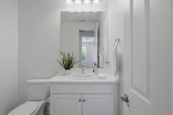 a bathroom with a sink a toilet and mirror