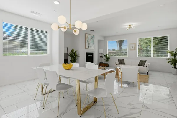 a view of a dining room and livingroom with furniture a livingroom and chandelier