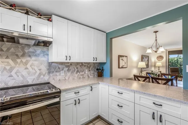 a kitchen with white cabinets and appliances