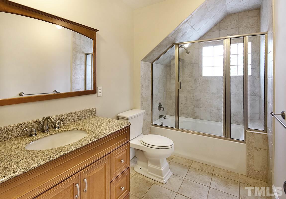2411 Bedford Avenue Raleigh, NC 27607 - Photo 22 of 28 a bathroom with a granite countertop sink toilet mirror and shower