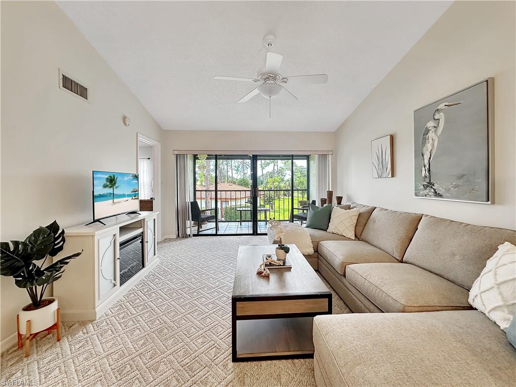 905 Augusta Boulevard, Unit 9056 Naples, FL 34113 - Photo 11 of 28 Carpeted living room featuring lofted ceiling and ceiling fan