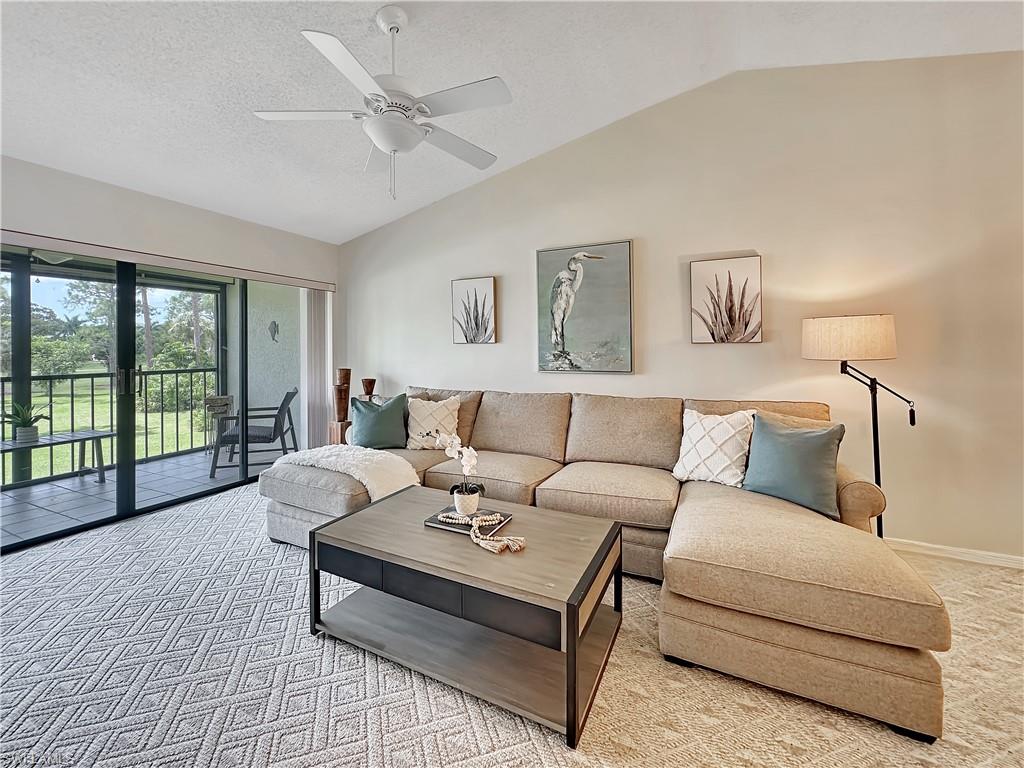 905 Augusta Boulevard, Unit 9056 Naples, FL 34113 - Photo 13 of 28 Carpeted living room with lofted ceiling, ceiling fan, and a textured ceiling