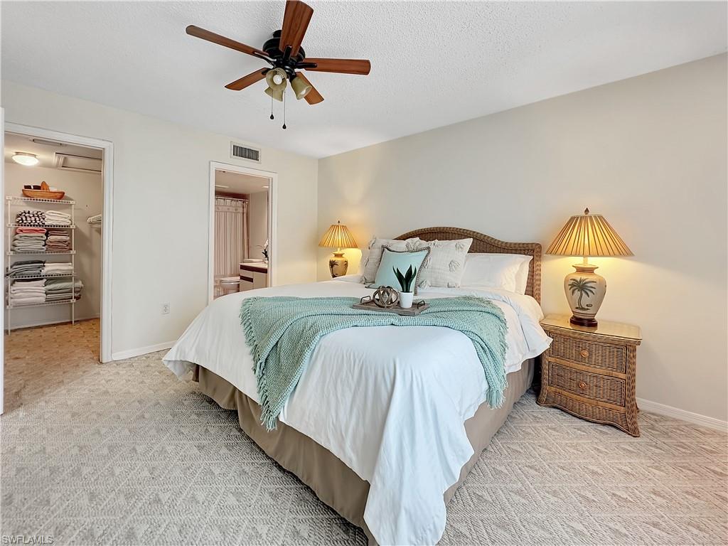 905 Augusta Boulevard, Unit 9056 Naples, FL 34113 - Photo 18 of 28 Bedroom with light colored carpet, a spacious closet, ceiling fan, and a closet