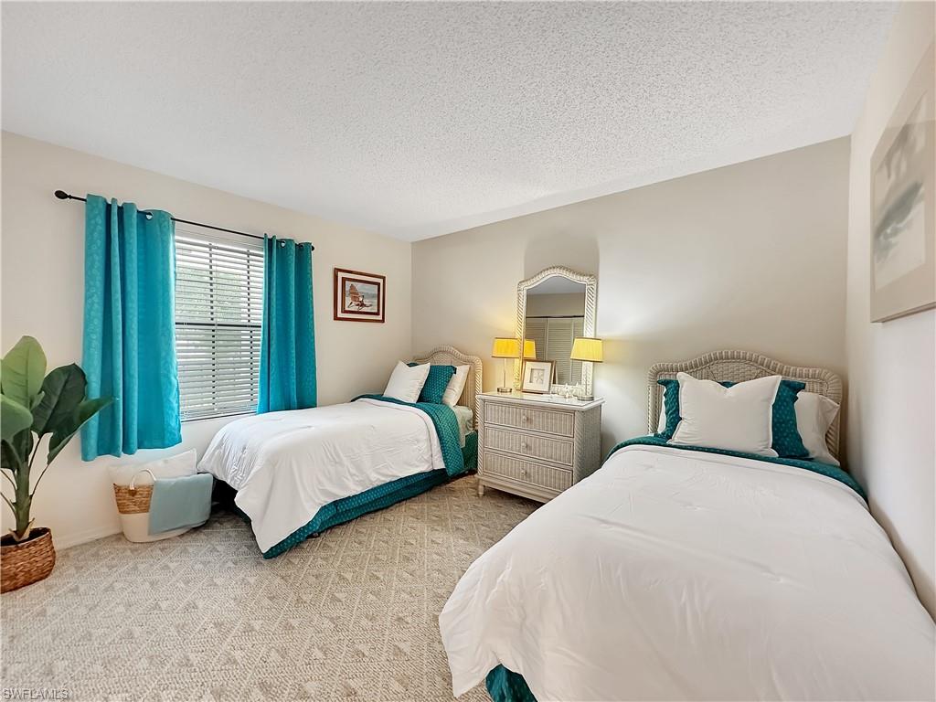 905 Augusta Boulevard, Unit 9056 Naples, FL 34113 - Photo 22 of 28 Bedroom featuring a textured ceiling and carpet flooring