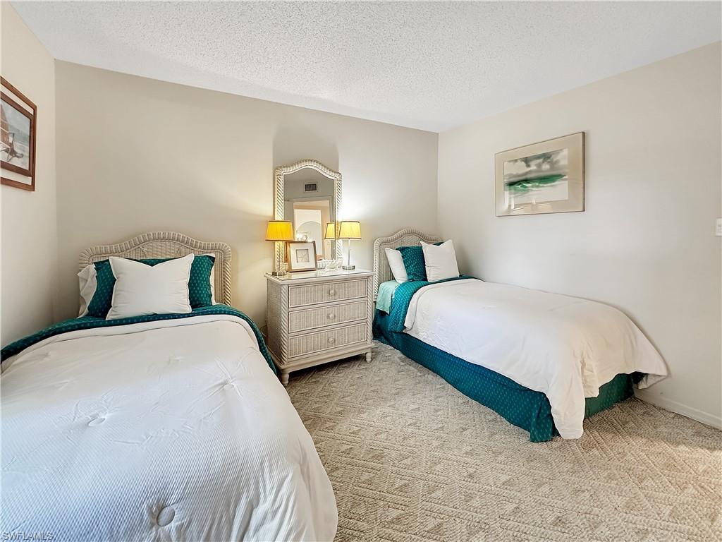905 Augusta Boulevard, Unit 9056 Naples, FL 34113 - Photo 23 of 28 Carpeted bedroom featuring a textured ceiling