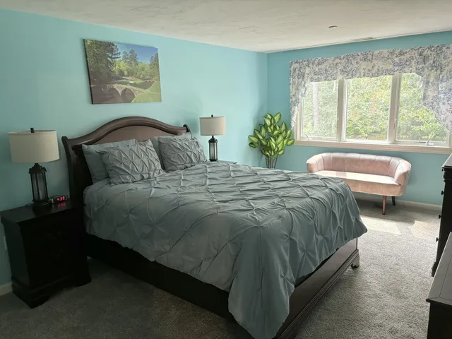 a large bed sitting in a bedroom next to a window