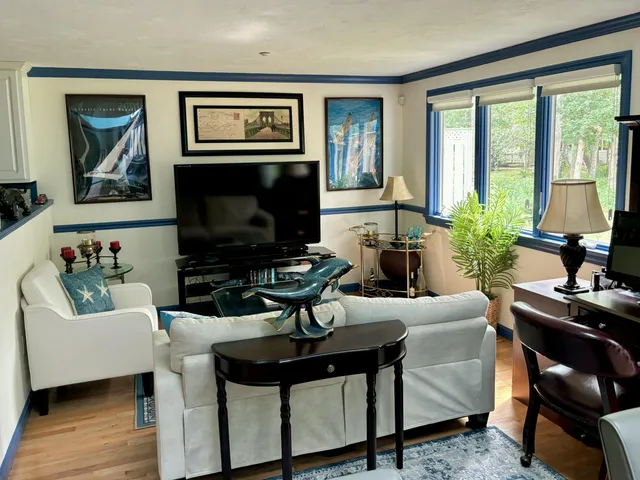 a living room with furniture a large window and a fireplace