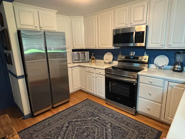 a kitchen with stainless steel appliances granite countertop a stove a microwave and a refrigerator