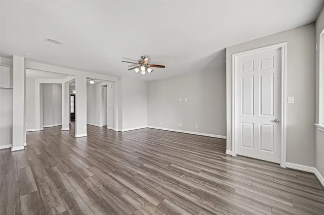 a view of an empty room with wooden floor