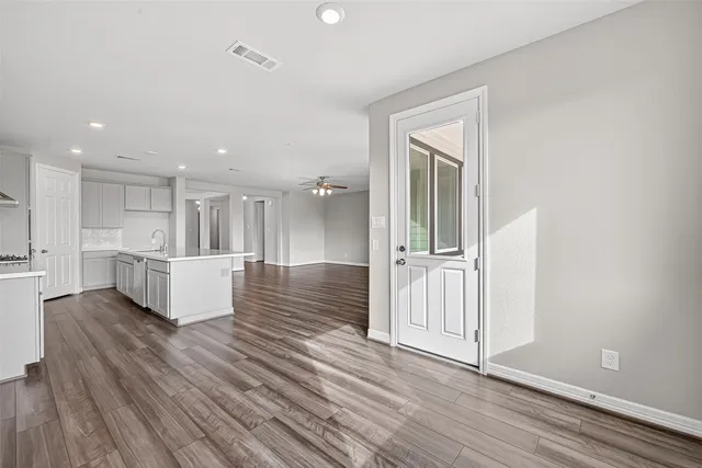 a view of a big room with wooden floor and windows