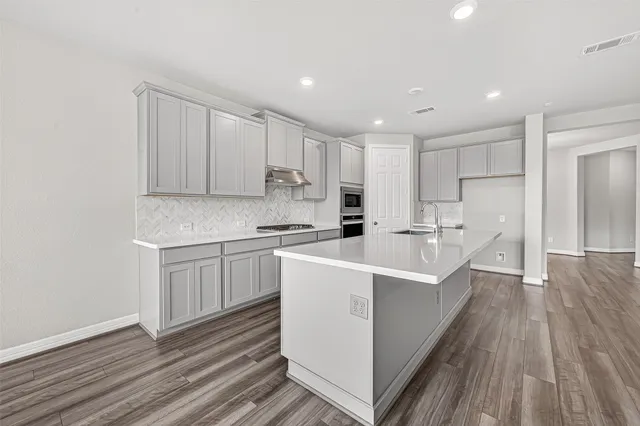 a large white kitchen with white cabinets stove and white stainless steel appliances