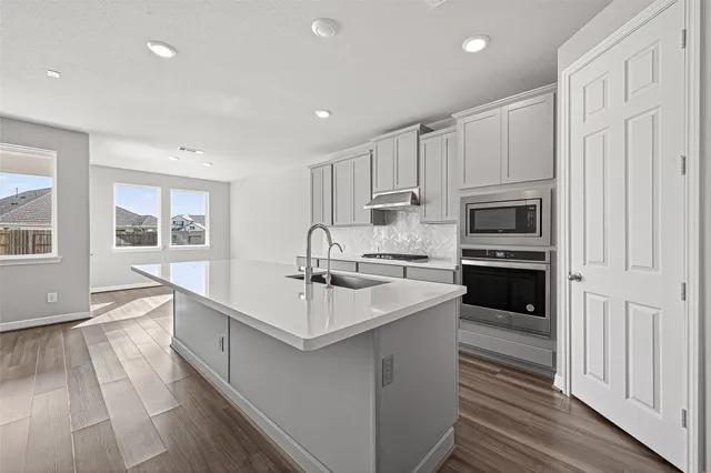 a large white kitchen with a sink stove and refrigerator