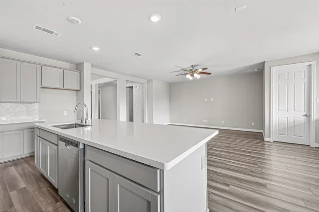 a kitchen with a sink chandelier and wooden floor