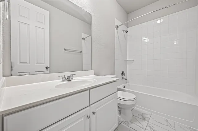 a bathroom with a sink a toilet and a large mirror