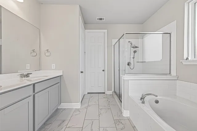 a bathroom with a tub a sink and mirror