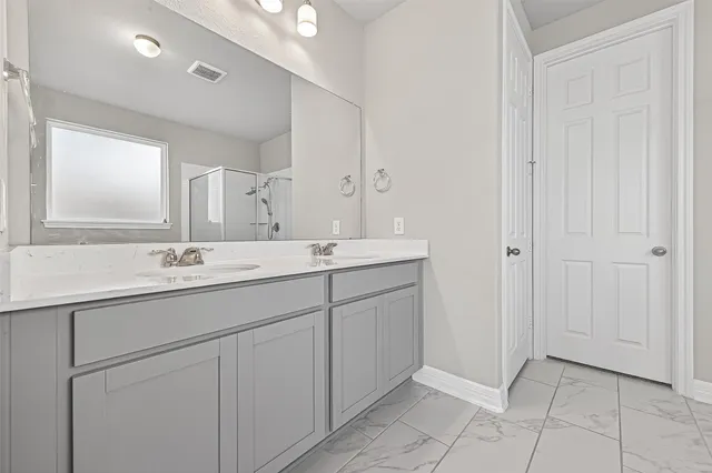 a bathroom with a double vanity sink and a mirror