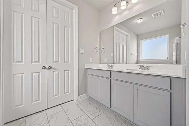 a bathroom with a double vanity sink and a mirror