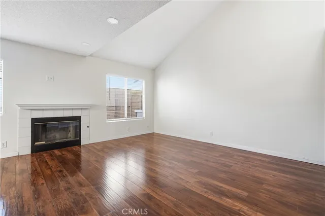 an empty room with wooden floor and entrance