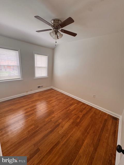 1090 Cameron Road Baltimore, MD 21212 - Photo 14 of 19 an empty room with wooden floor fan and windows
