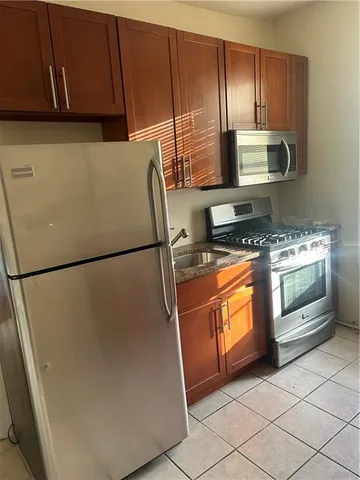 a kitchen with stainless steel appliances granite countertop a refrigerator a stove a sink and dishwasher