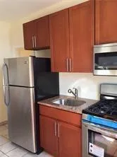 a kitchen with granite countertop a refrigerator stove and microwave