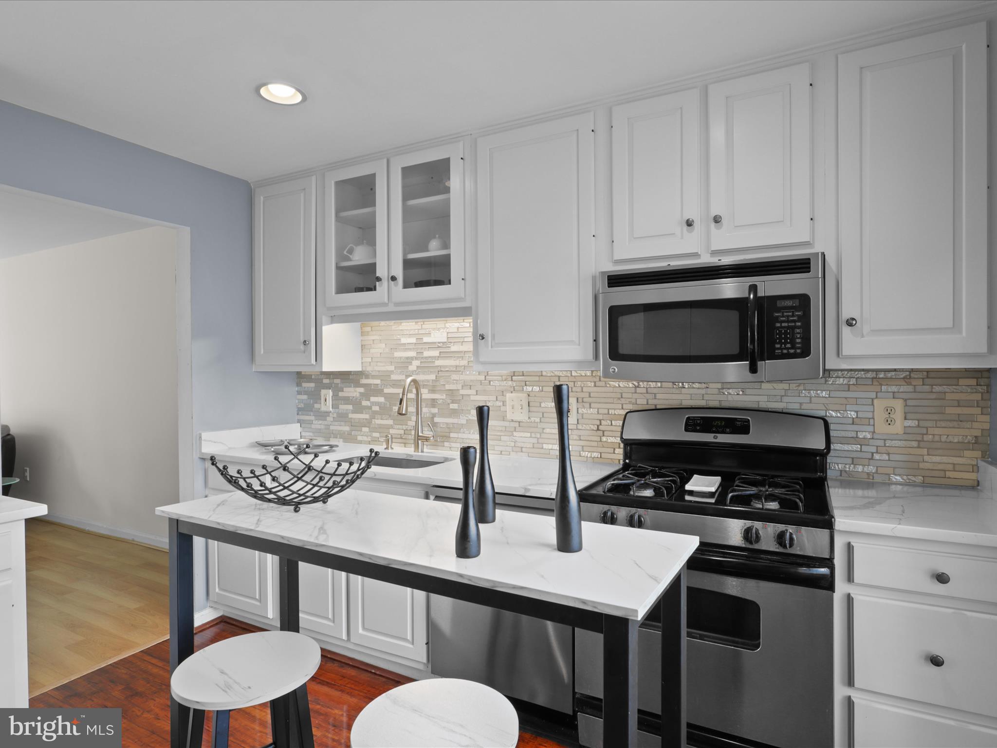 8068 Dulciana Court Springfield, VA 22153 - Photo 3 of 36 a kitchen with stainless steel appliances a stove a sink cabinets and a dining table