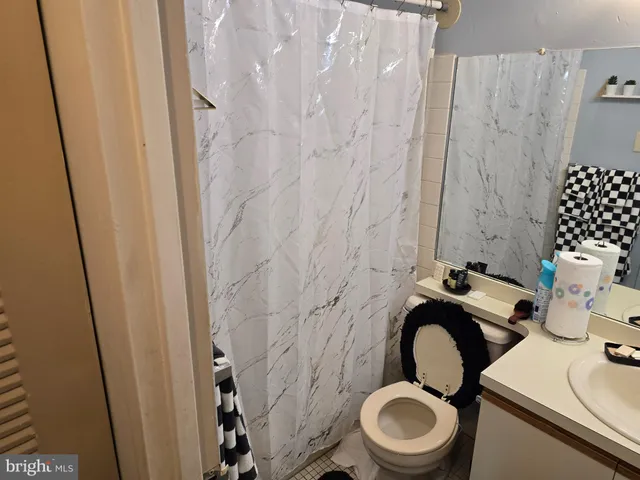 a bathroom with a toilet and a shower curtain