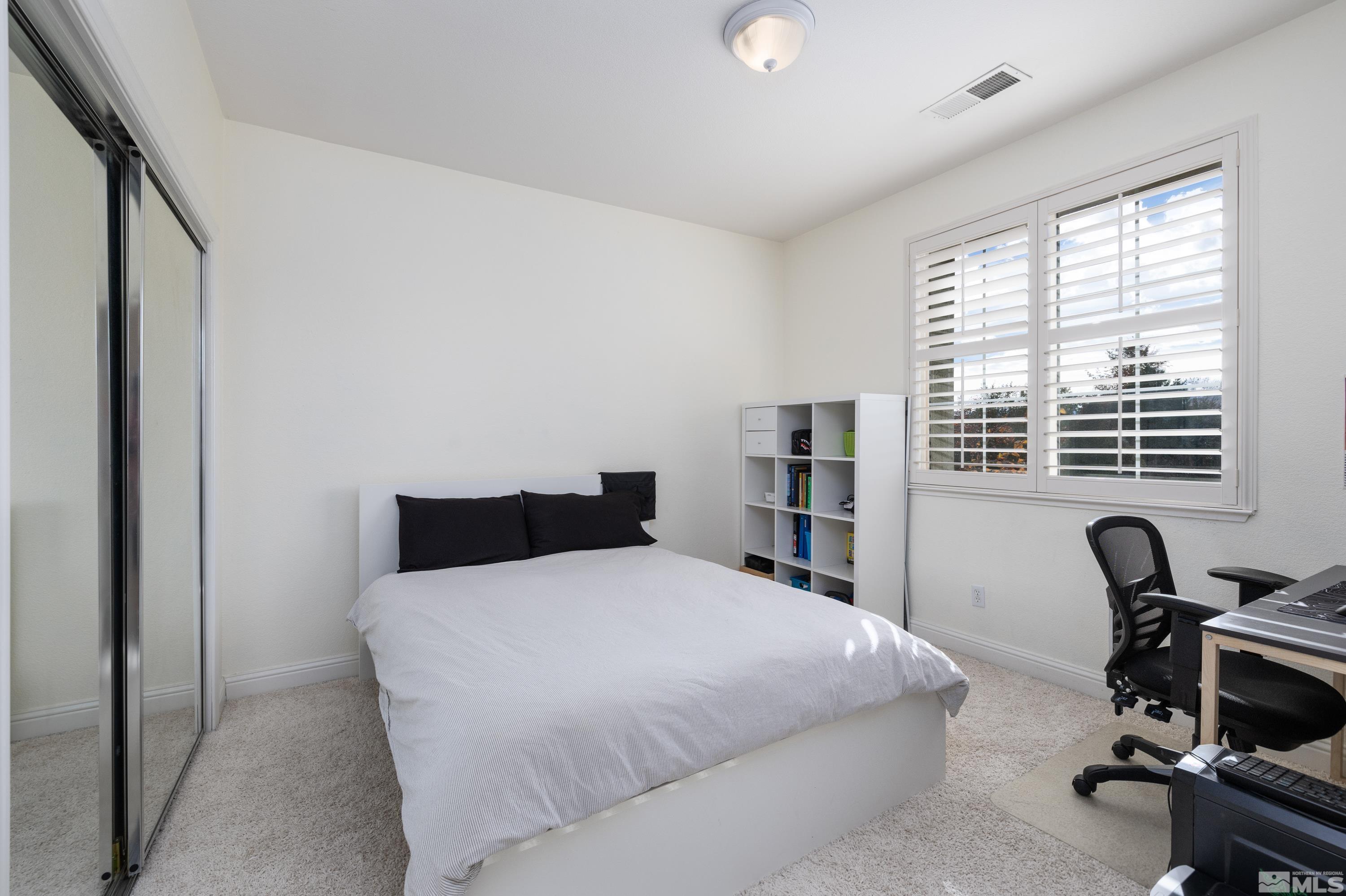 2585 Baton Drive Reno, NV 89521 - Photo 12 of 28 a bedroom with a bed a computer on desk and a large window