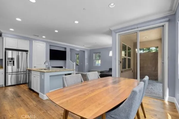a large kitchen with a table chairs refrigerator and microwave