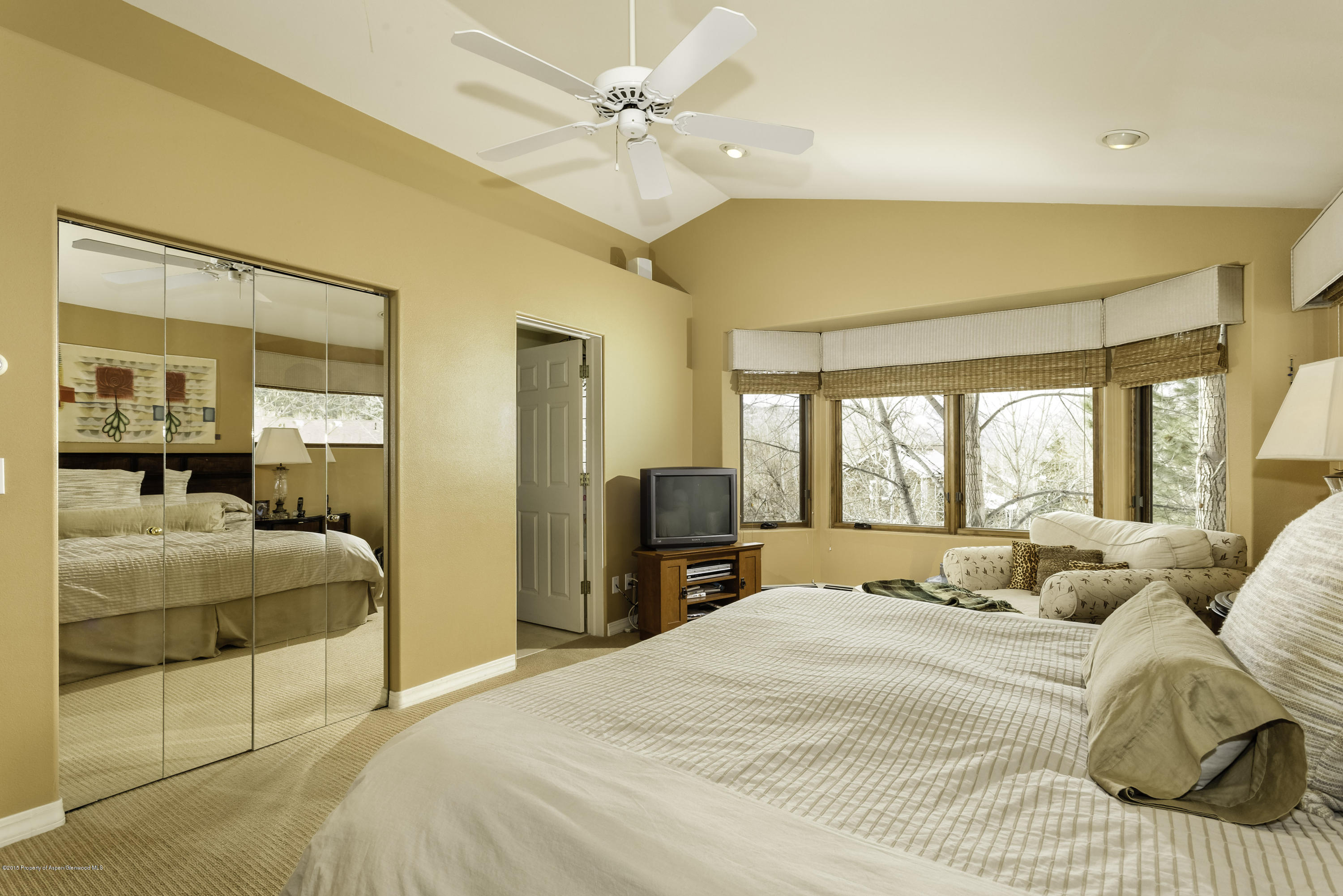 808 Kestrel Court Basalt, CO 81621 - Photo 12 of 22 a bedroom with a large bed and a chandelier