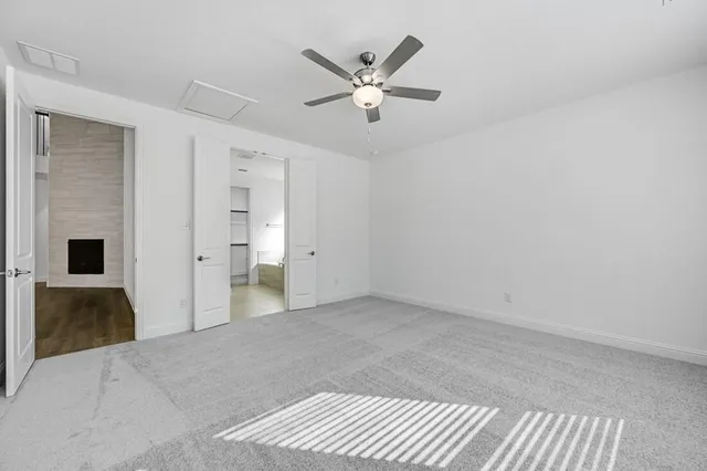 a view of an empty room with a ceiling fan