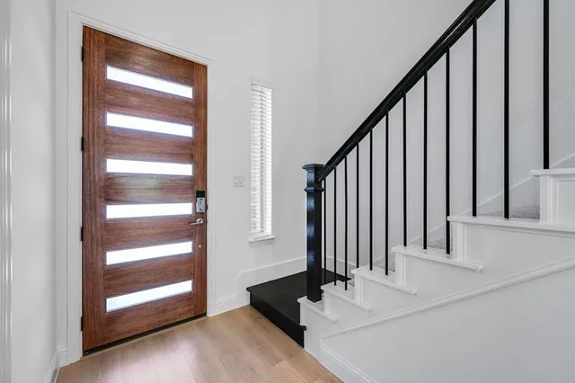 a view of a hallway with staircase and white door