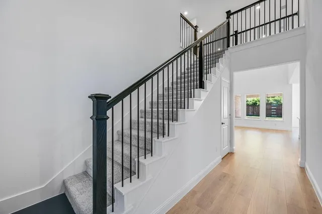 a view of staircase with wooden floor and white walls