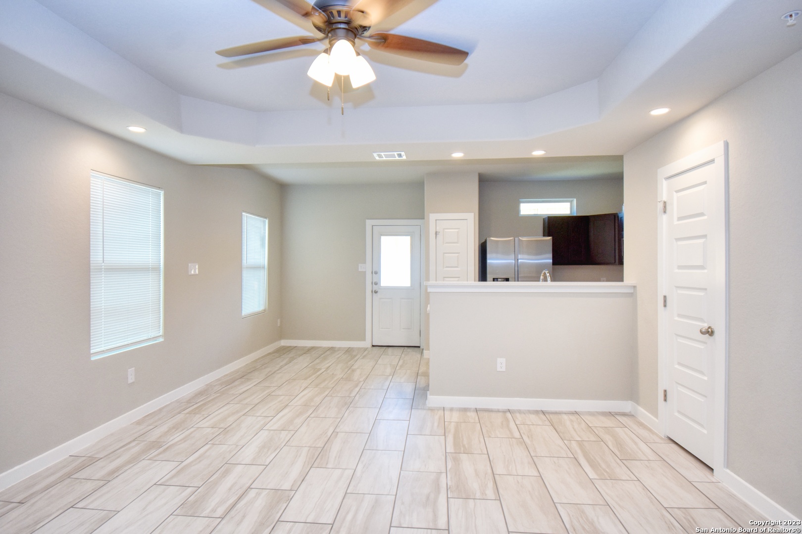 8318 Via Verona, Unit 103 San Antonio, TX 78227 - Photo 4 of 18 wooden floor in an empty room with a kitchen