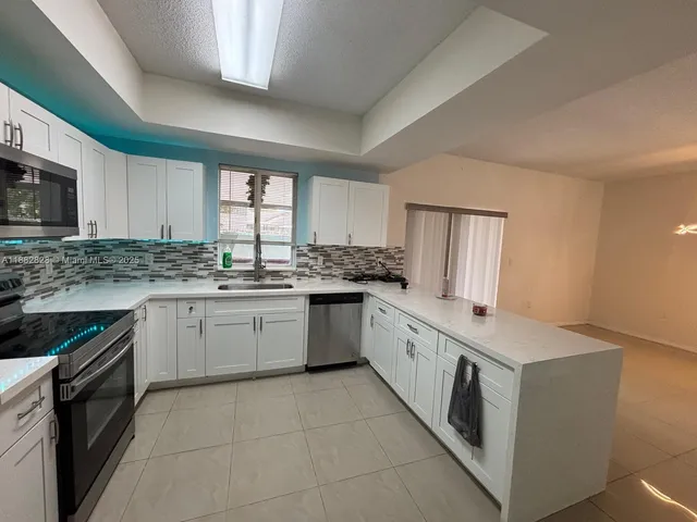 a kitchen with a stove top oven sink and cabinets