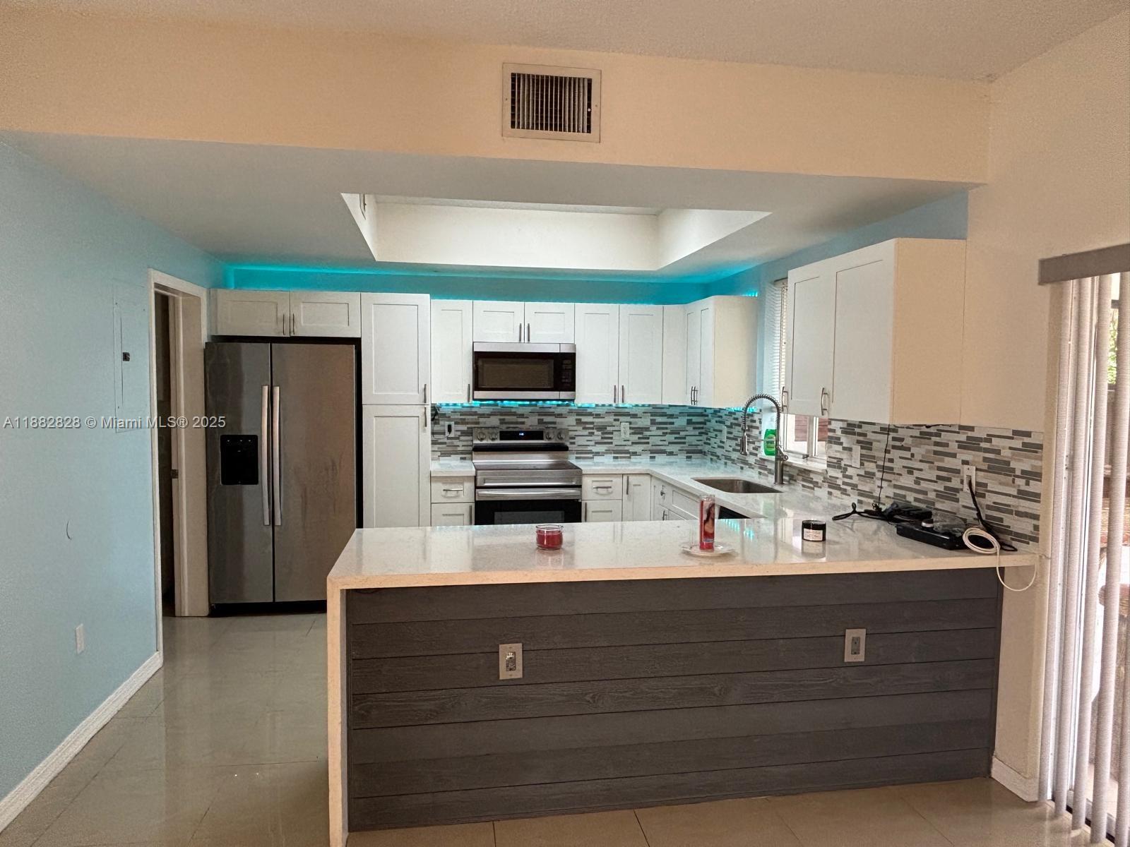1133 Southeast 13th Terrace Homestead, FL 33035 - Photo 6 of 14 a kitchen with stainless steel appliances a refrigerator sink and microwave