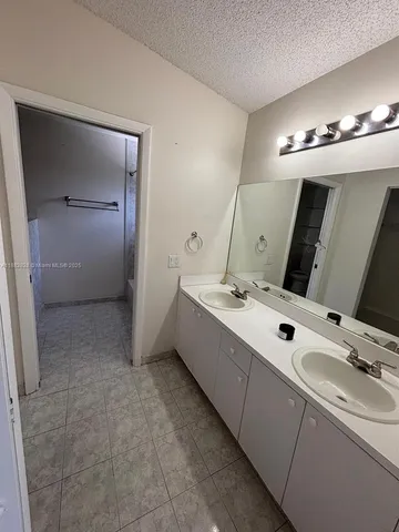 a bathroom with a double vanity sink and a mirror