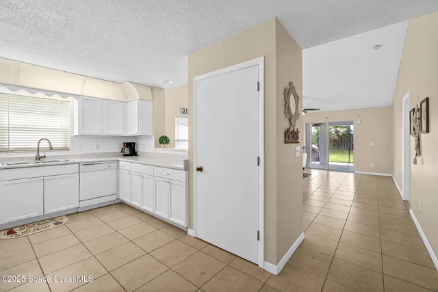a kitchen with a refrigerator sink and cabinets