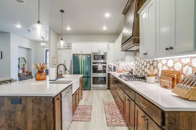 a kitchen with stainless steel appliances a sink stove and cabinets
