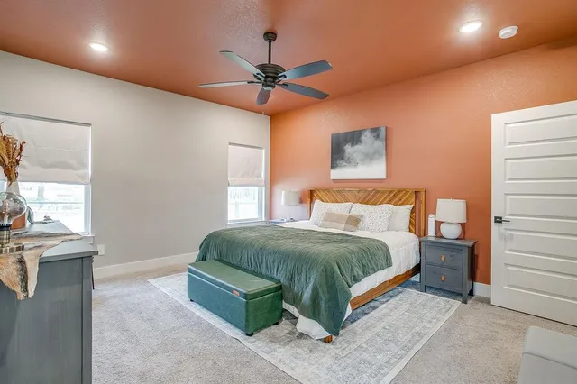 a spacious bedroom with a bed and a chandelier