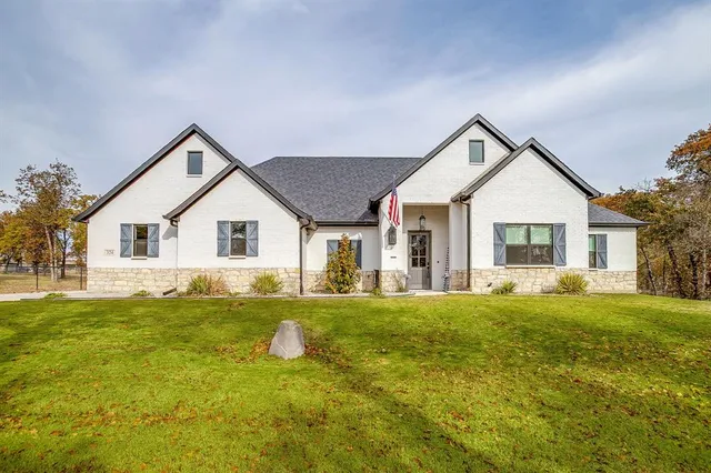 a view of a house with a big yard and potted plants