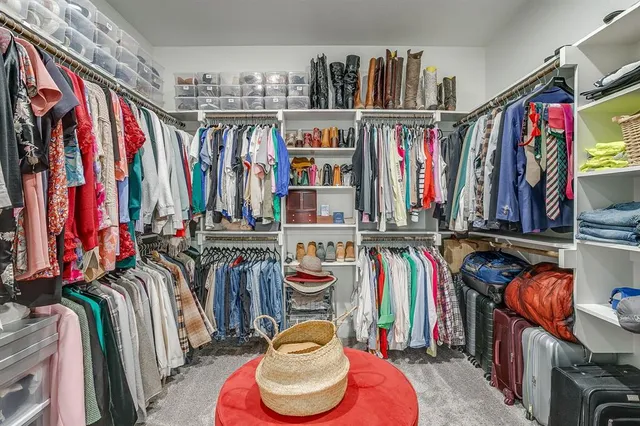 a view of walk in closet with clothes and shoes