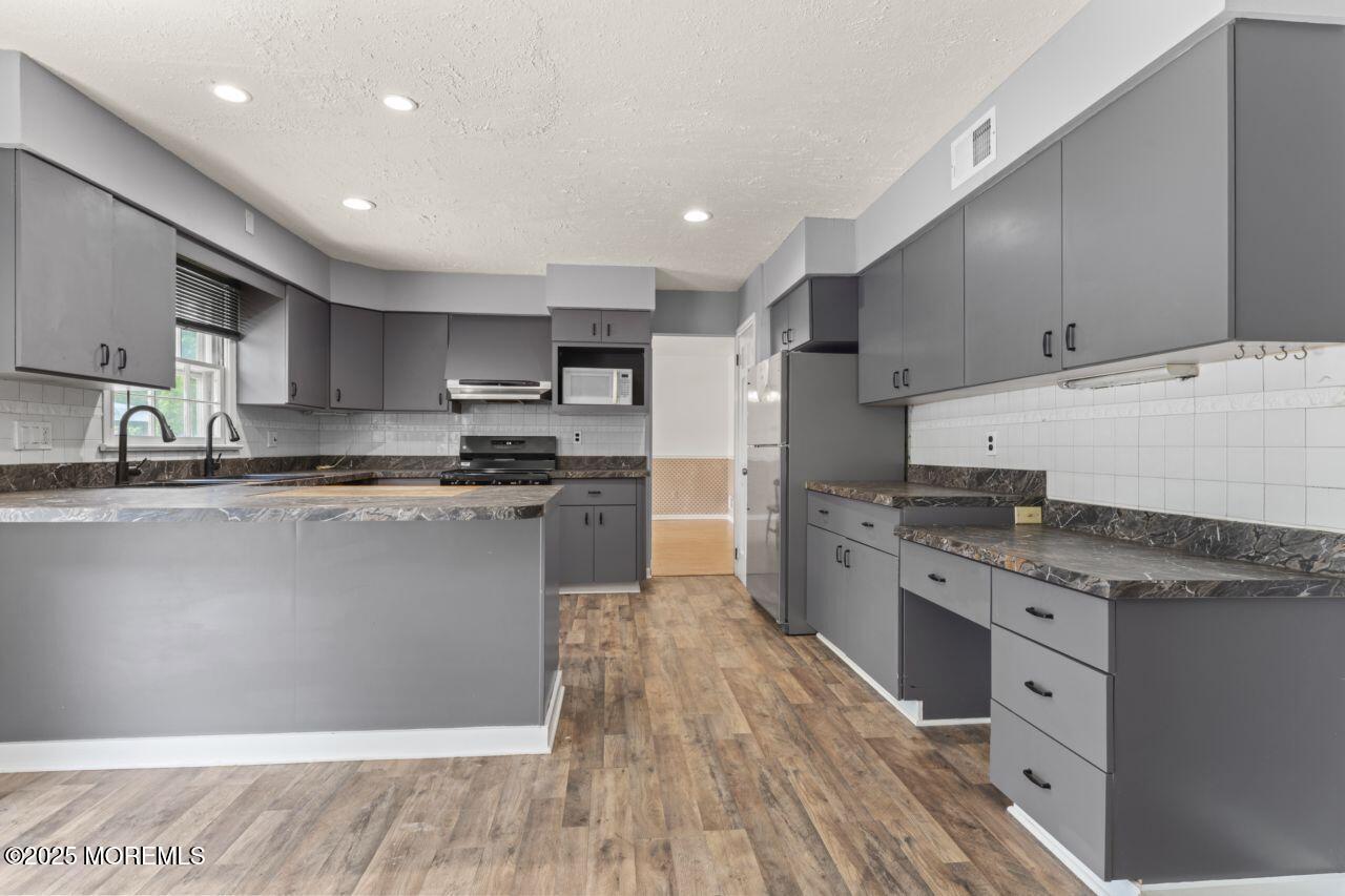 600 Driscol Drive Brick, NJ 08724 - Photo 5 of 35 a kitchen with stainless steel appliances granite countertop a stove a sink and a refrigerator