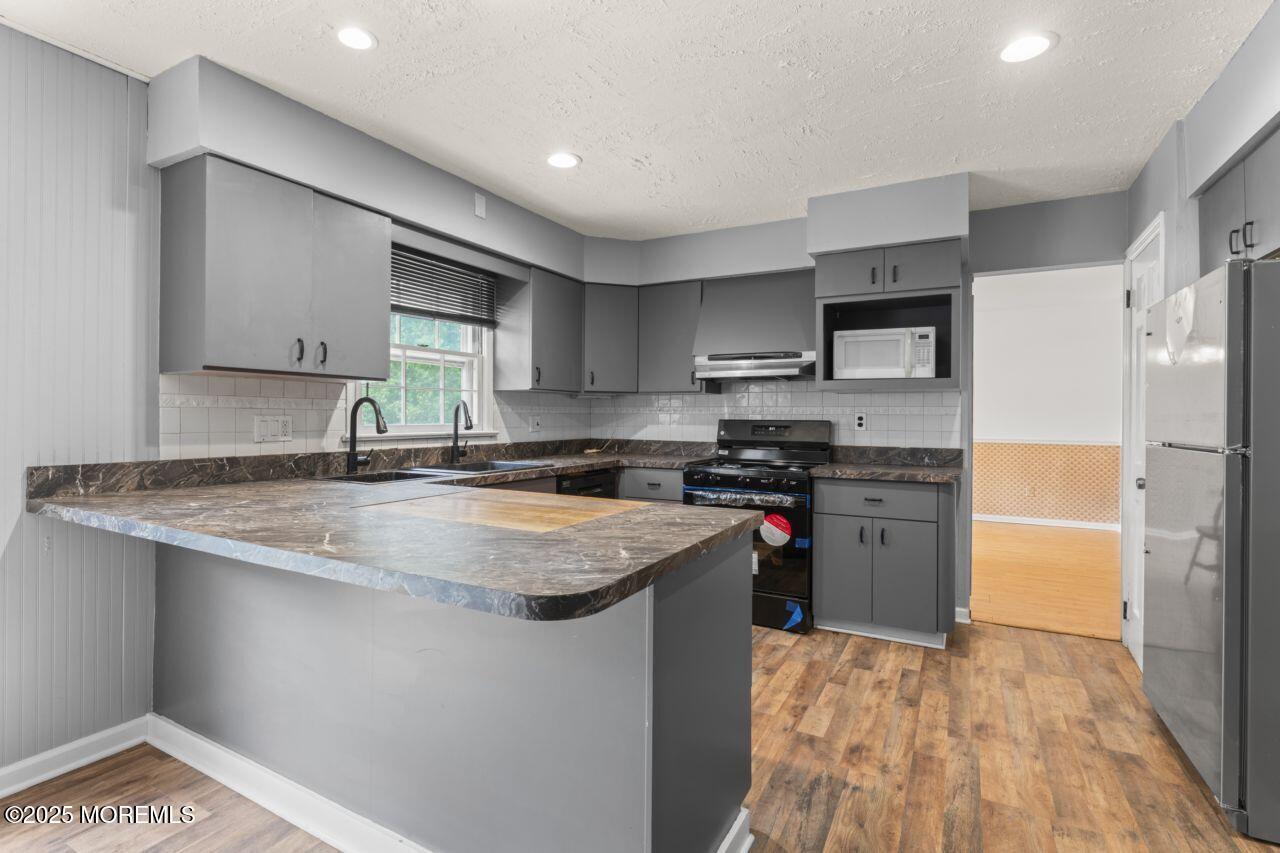 600 Driscol Drive Brick, NJ 08724 - Photo 6 of 35 a kitchen with stainless steel appliances granite countertop a sink stove and refrigerator