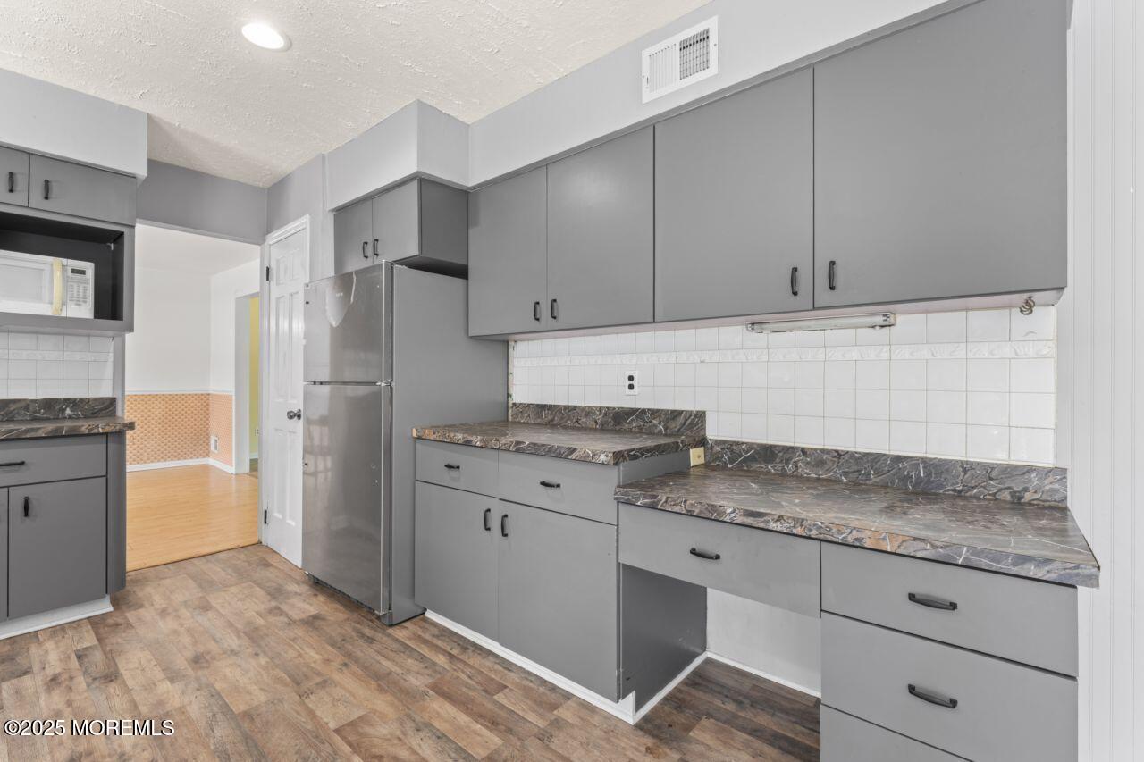 600 Driscol Drive Brick, NJ 08724 - Photo 10 of 35 a kitchen with granite countertop cabinets and refrigerator