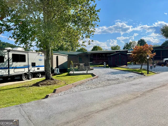 a view of swimming pool with outdoor seating and house in the background