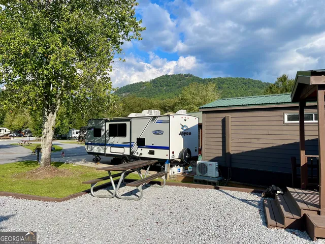 a view of a backyard with chairs and a fire pit