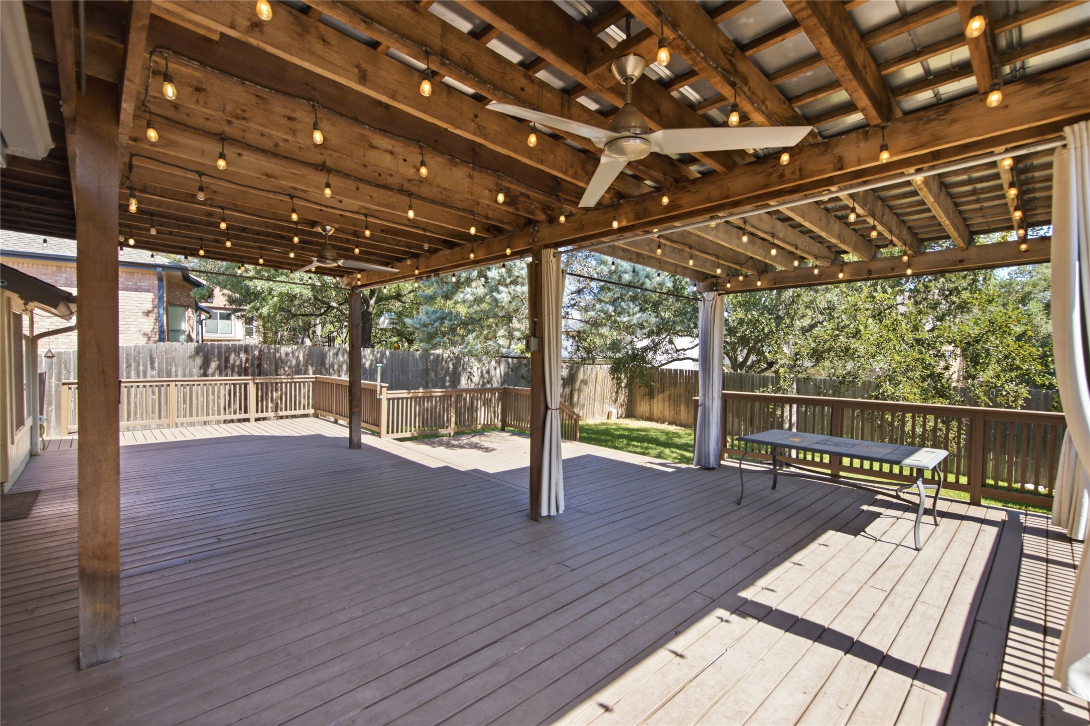 6032 Roxbury Lane Austin, TX 78739 - Photo 24 of 34 An expansive multi-level wooden deck features a large covered section with exposed timber beams.