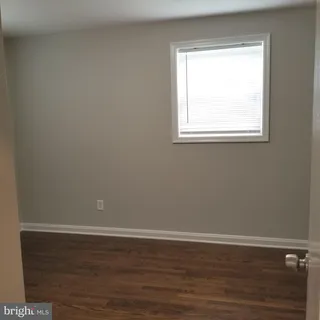 a view of a small space with wooden floor and a window